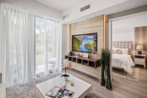 A modern bedroom with a large bed and a painting on the wall.