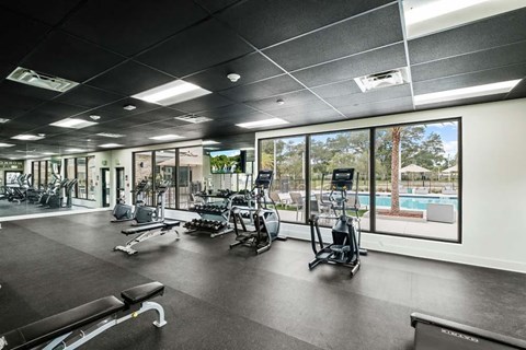A gym with a variety of equipment including treadmills, weights, and exercise machines.
