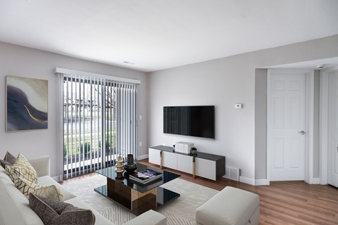 A living room with a white couch, a coffee table, and a painting on the wall.