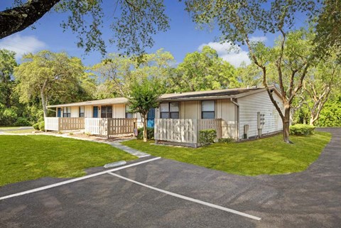 Two houses are situated in a grassy area with a paved road in between.