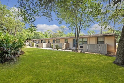 A row of houses with green lawns in front.