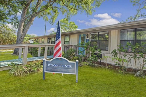A sign that says Welcome Center stands in front of a building.