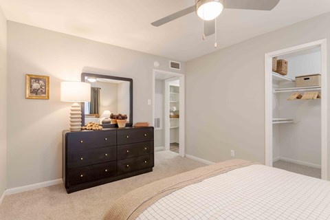 A bedroom with a black dresser and a mirror.