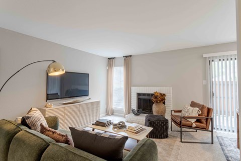 A living room with a fireplace, a couch, a chair, and a television.