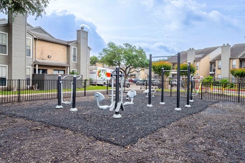 A playground with a black diamond-shaped area and white swan sculptures.