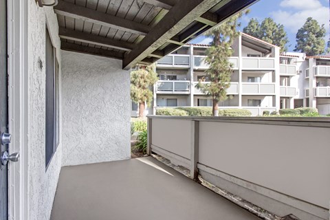 A balcony with a view of apartment buildings.