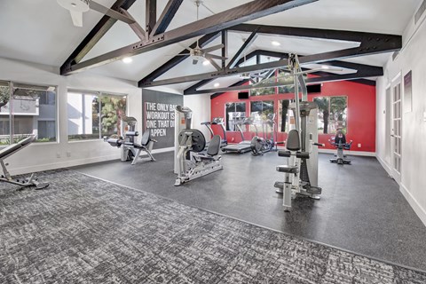 A gym with a variety of equipment and a sign that says
