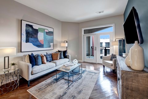 A living room with a white couch, a coffee table, and a painting on the wall.
