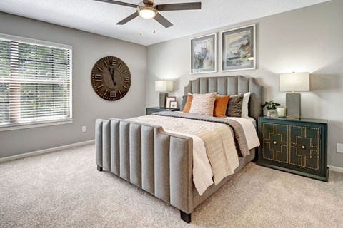 A bedroom with a large bed and a ceiling fan.