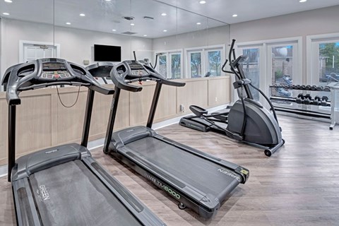 Three treadmills are lined up in a gym.