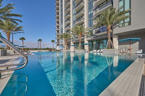 A long rectangular pool with a metal railing on the left side.