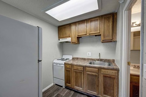A kitchen with wooden cabinets and a white dishwasher.