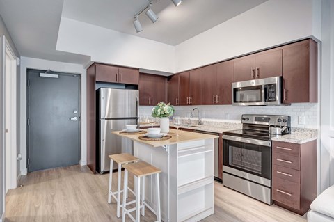 A modern kitchen with a refrigerator, oven, and microwave.