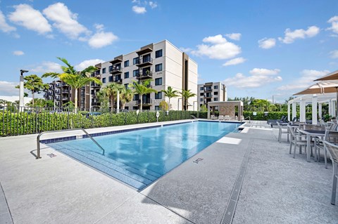 A swimming pool in front of a modern apartment building.