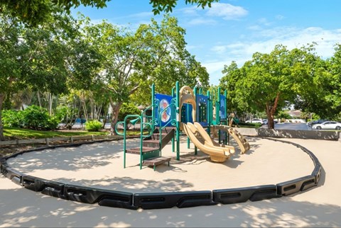 A playground with a slide, swings, and a seesaw.
