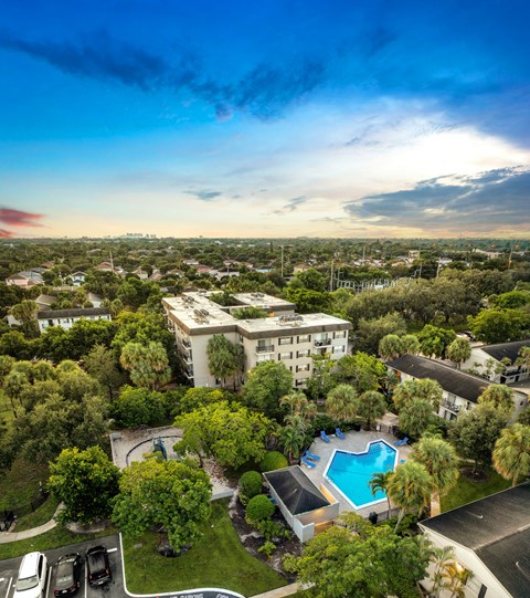A bird's eye view of a residential area with a swimming pool and apartment buildings.