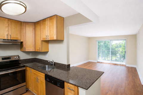 A kitchen with wooden cabinets and black appliances.