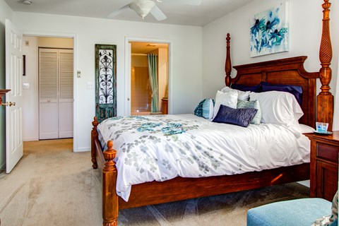 A bedroom with a large bed and a ceiling fan.