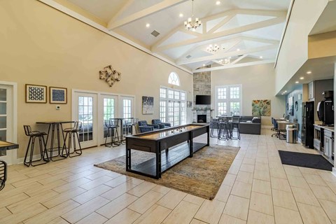 A large, well-lit living room with a central coffee table and a bar area.