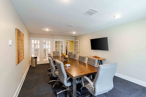A conference room with a long table and chairs.