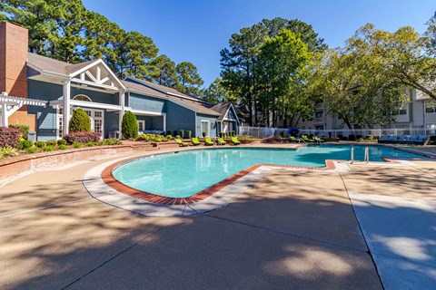 A swimming pool in a residential area with a house in the background.