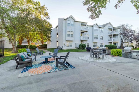 A patio area with a table and chairs surrounded by apartment buildings.