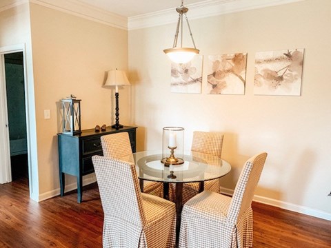 A dining room with a table and chairs.