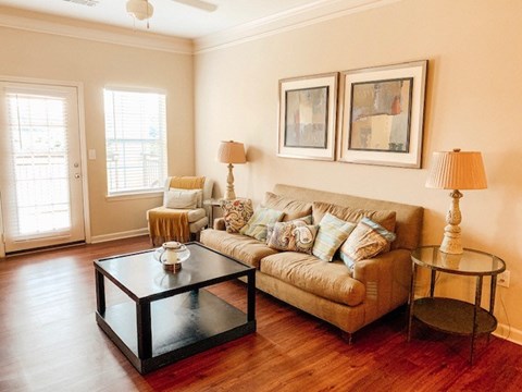 A living room with a couch, two chairs, a coffee table, and two lamps.