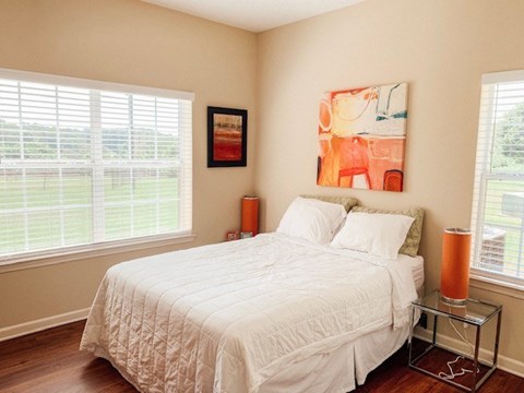 A bedroom with a large bed and a painting on the wall.