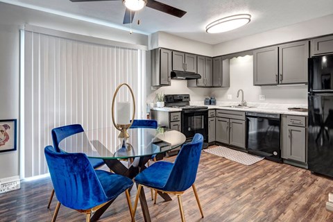 A kitchen with a table and chairs.