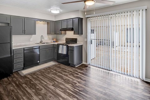 A kitchen with dark wood floors and white walls.