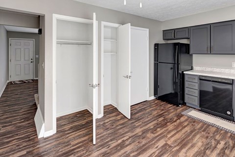 A kitchen with a black refrigerator and white cabinets.