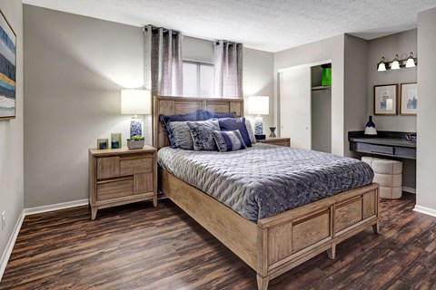 A bedroom with a large bed and wooden furniture.