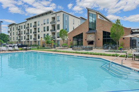 A swimming pool in front of a building with a red brick exterior.