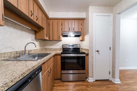 A kitchen with a sink, stove, and oven.