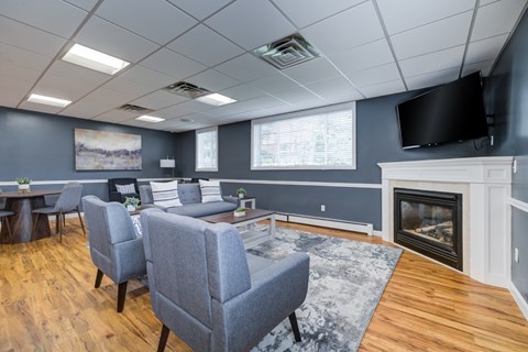 A living room with a grey couch and a fireplace.