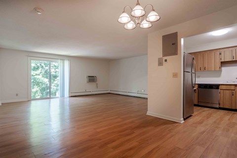 A kitchen area with a refrigerator, oven, and cabinets is visible.