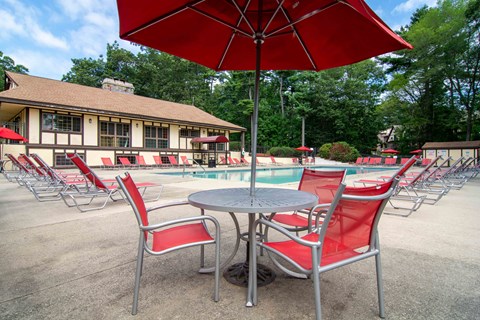 A table with chairs and an umbrella in front of a building.