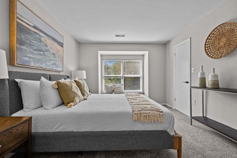 A bedroom with a large bed and a painting on the wall.