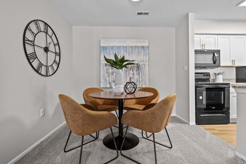 A dining room with a table and chairs.