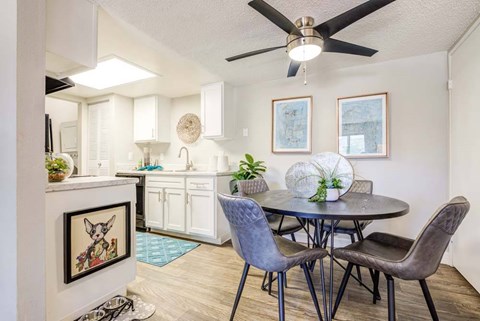 A dining room with a table and chairs.