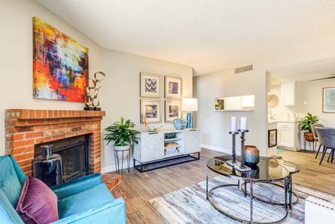 A living room with a blue couch and a fireplace.