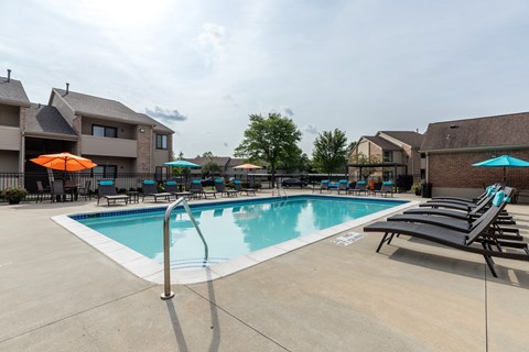 A swimming pool with a ladder and sun loungers.