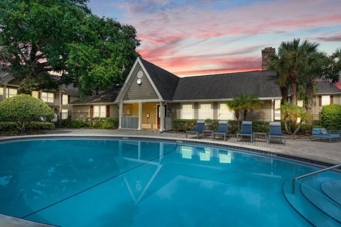 A house with a pool in front of it.