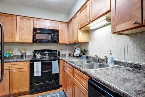 A kitchen with wooden cabinets and a black stove top oven.