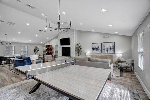 A spacious living room with a ping pong table in the center.