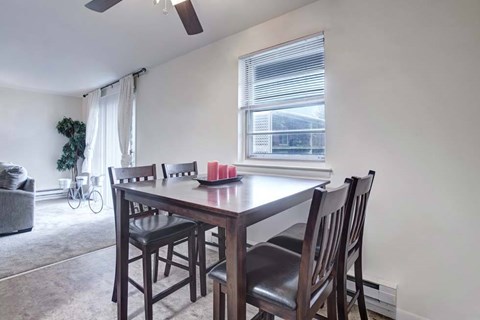 A dining room with a table and chairs.