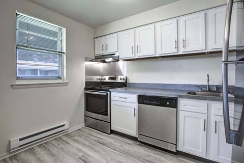 A kitchen with white cabinets and stainless steel appliances.