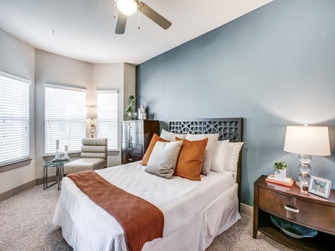 A bedroom with a large bed and a ceiling fan.