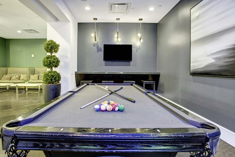 A pool table with balls and cues in the middle of it.